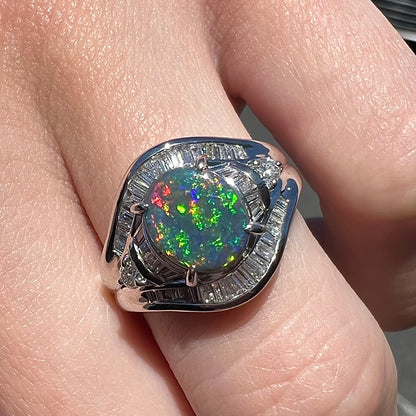 A platinum Lightning Ridge black opal ring set with baguette cut diamonds.  The opal is an oval cabochon cut.