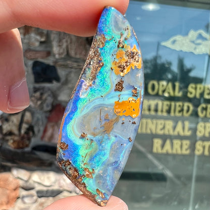 A freeform cut, loose black boulder opal stone from Queensland, Australia.
