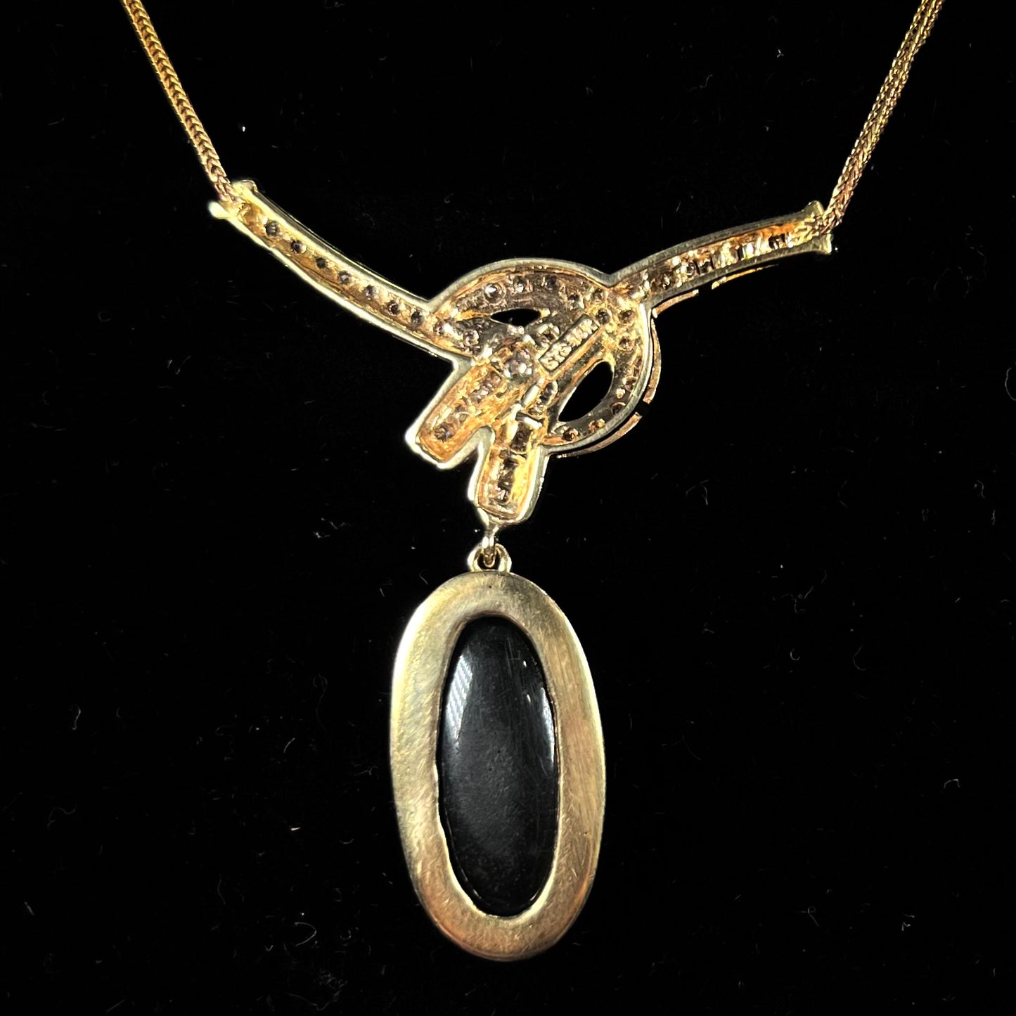 A gold black opal and diamond necklace.  There are round, princess cut, and baguette cut diamonds.