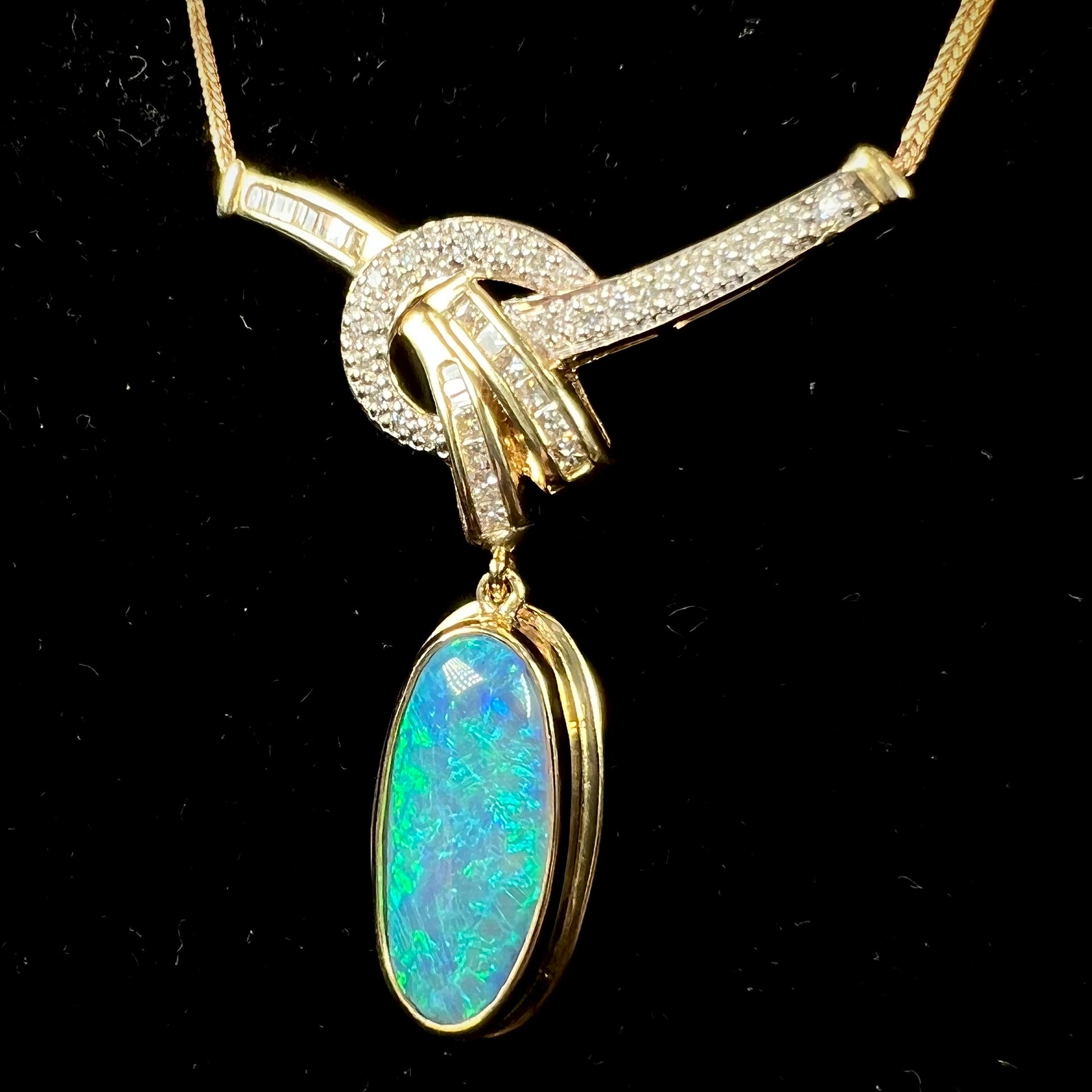 A gold black opal and diamond necklace.  There are round, princess cut, and baguette cut diamonds.