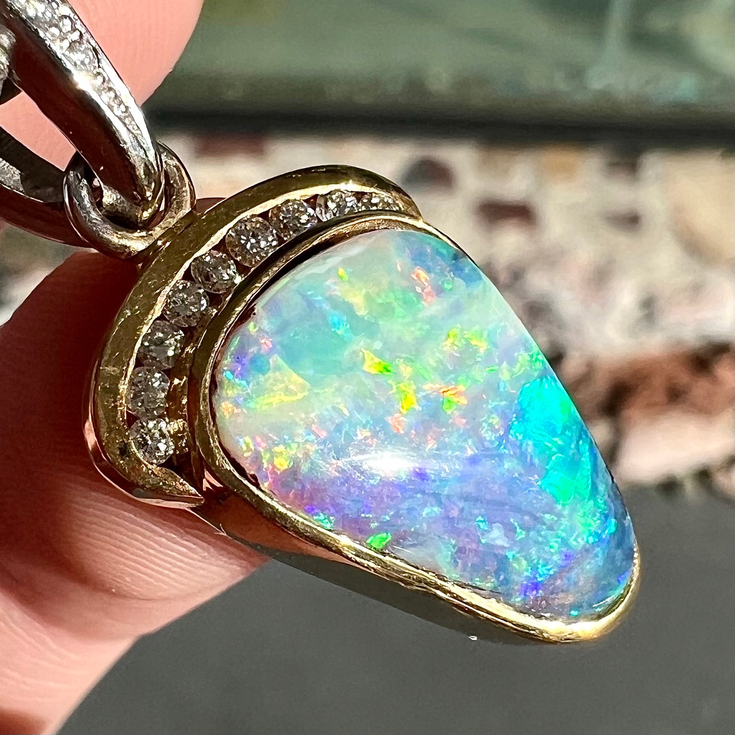 A ladies' 18kt two tone white and yellow gold Australian black boulder opal and diamond pendant.