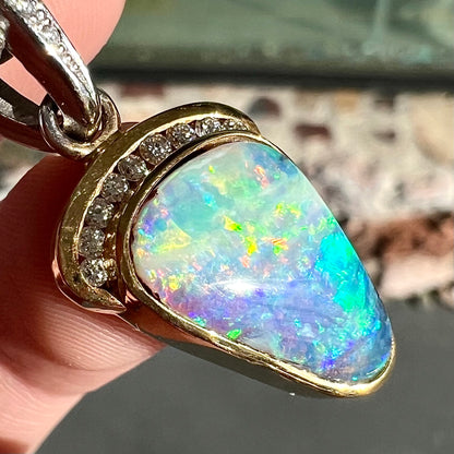 A ladies' 18kt two tone white and yellow gold Australian black boulder opal and diamond pendant.