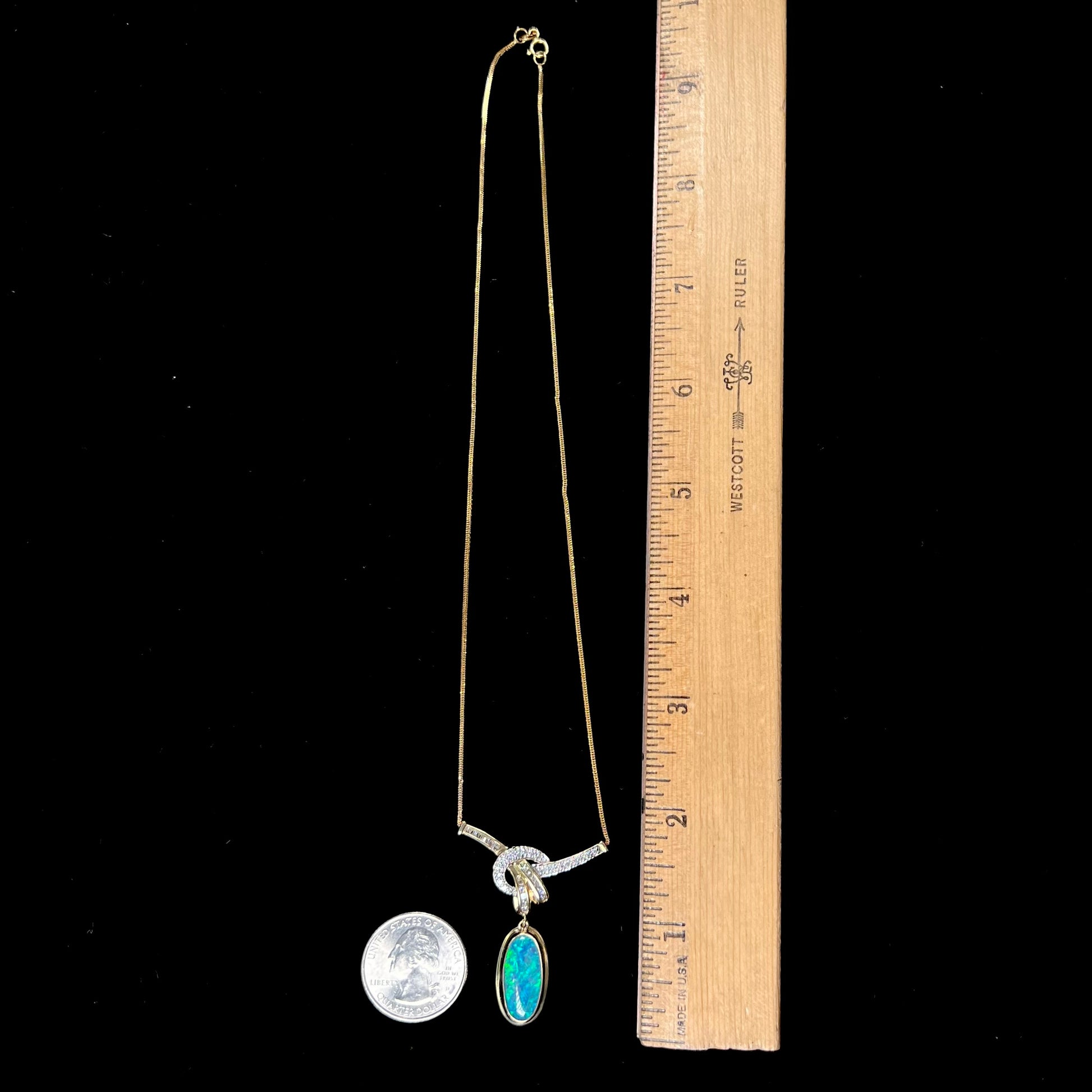A gold black opal and diamond necklace.  There are round, princess cut, and baguette cut diamonds.