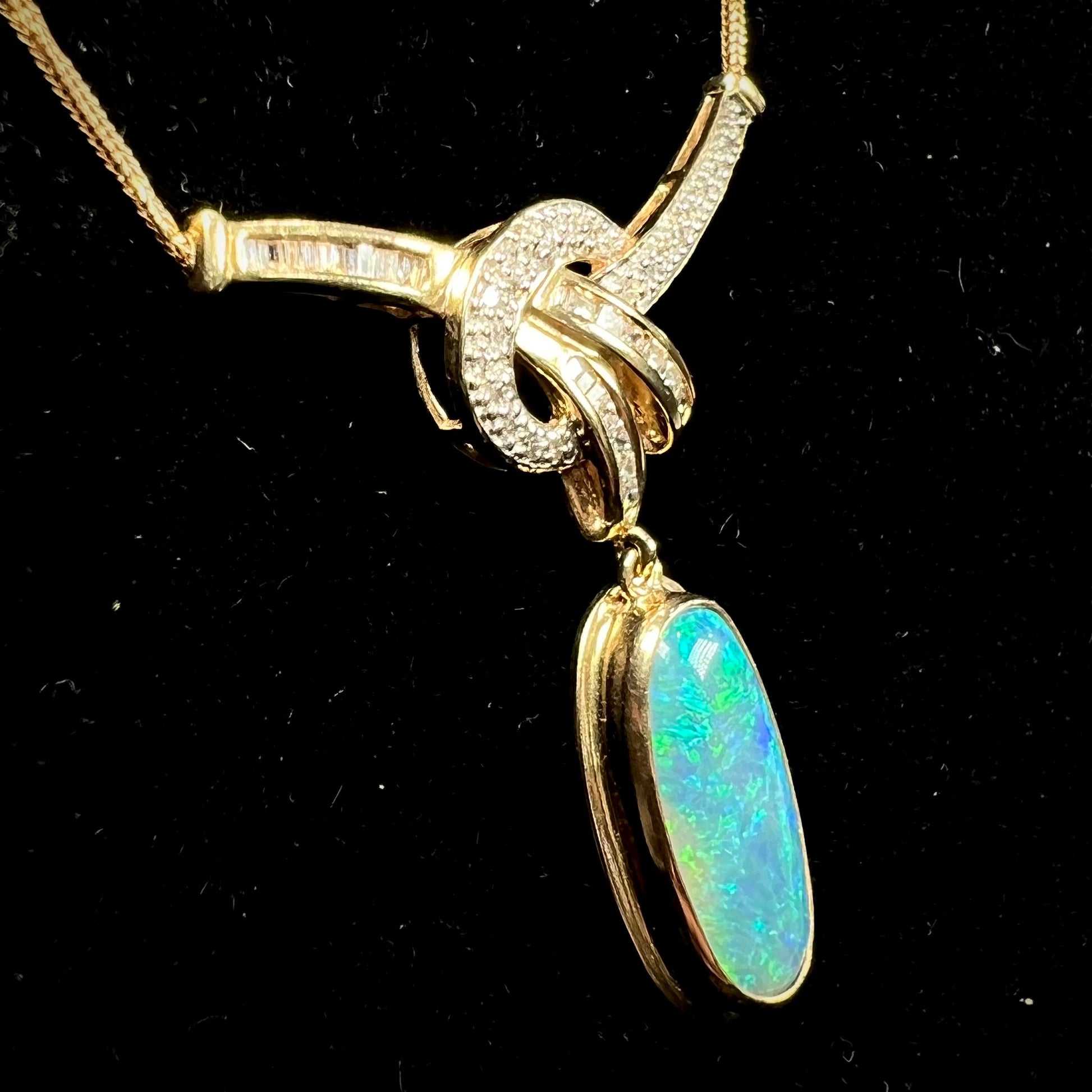 A gold black opal and diamond necklace.  There are round, princess cut, and baguette cut diamonds.