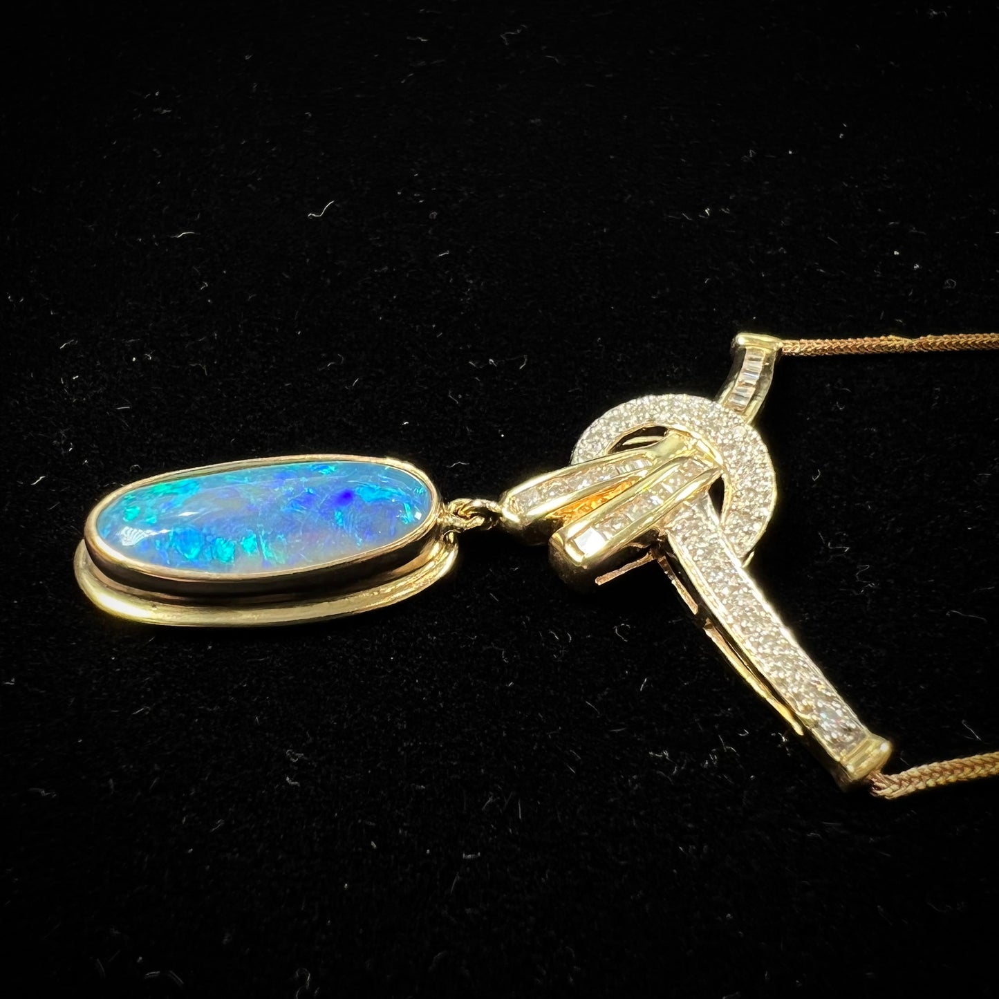 A gold black opal and diamond necklace.  There are round, princess cut, and baguette cut diamonds.