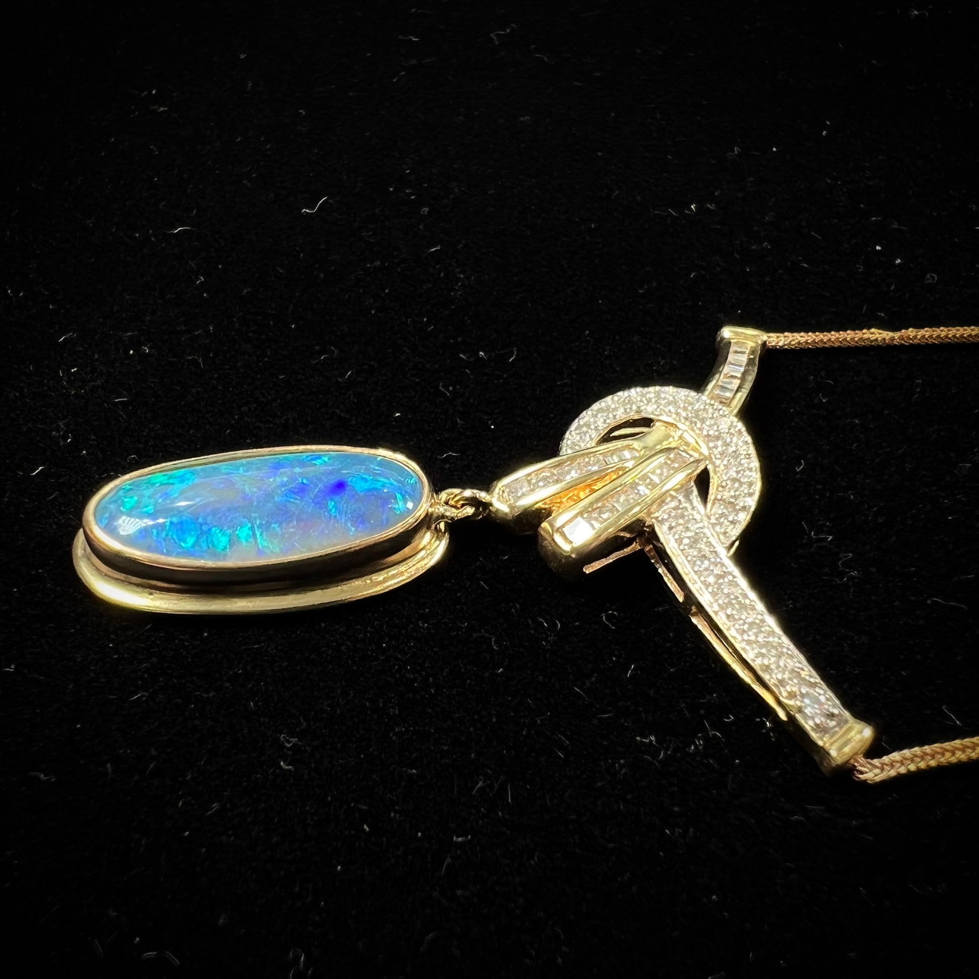 A gold black opal and diamond necklace.  There are round, princess cut, and baguette cut diamonds.