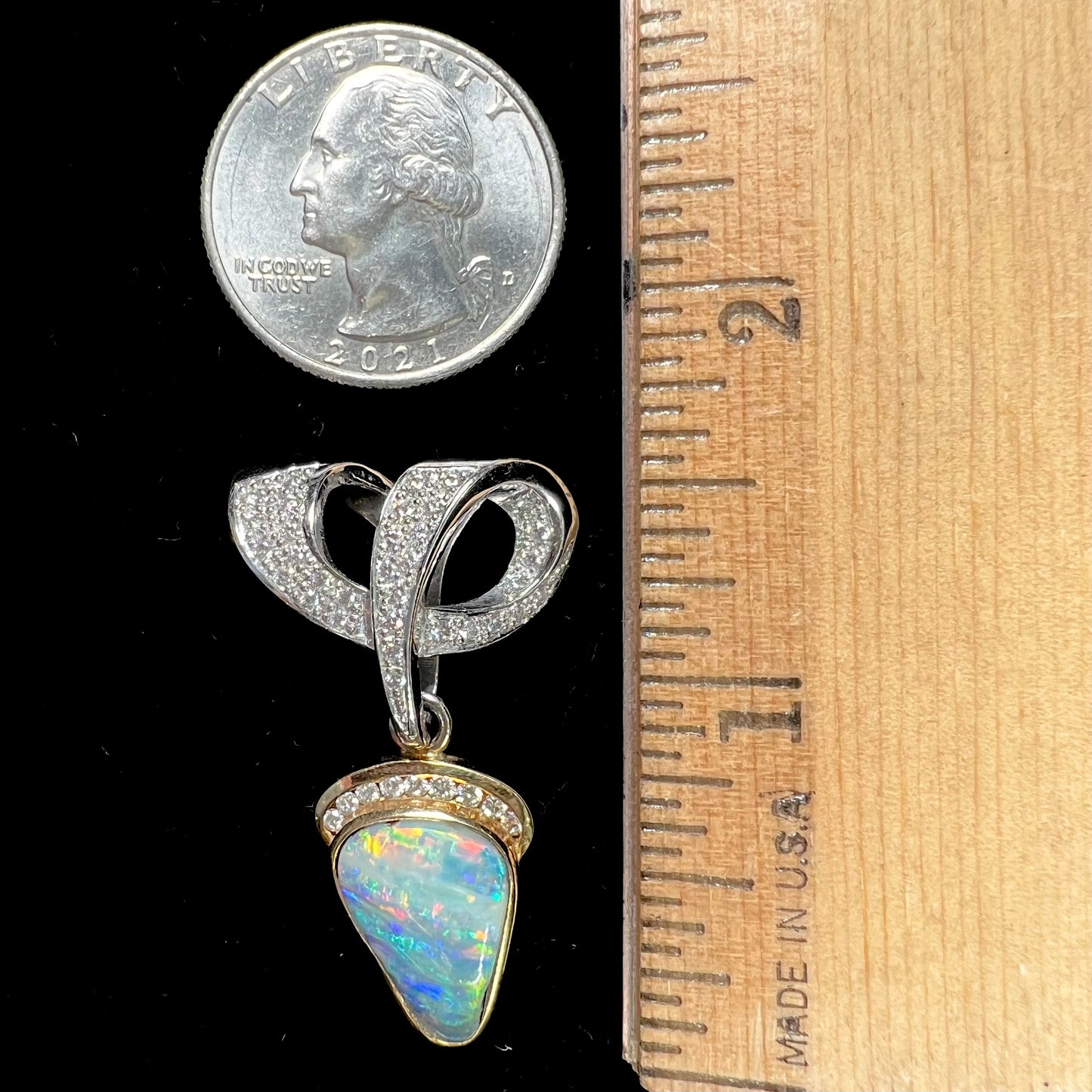 A ladies' 18kt two tone white and yellow gold Australian black boulder opal and diamond pendant.