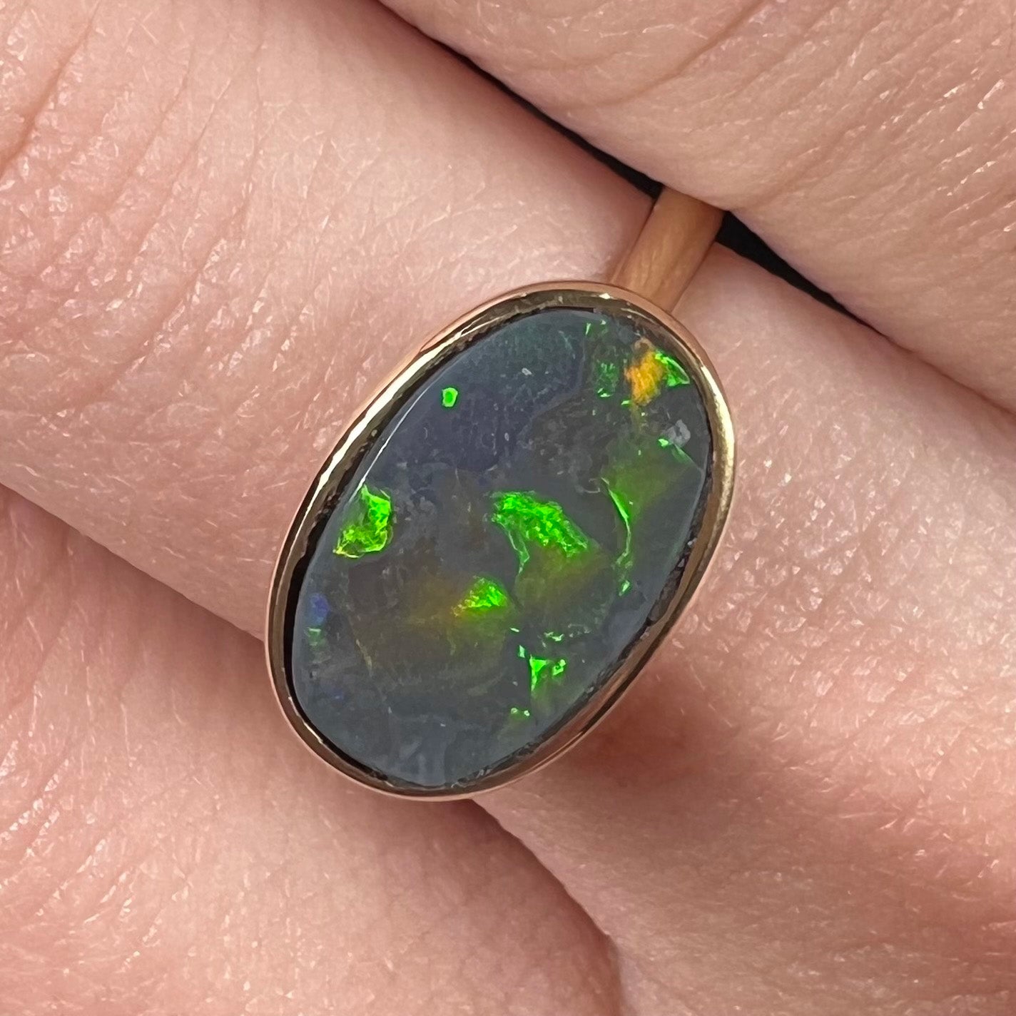 A ladies' yellow gold black opal solitaire ring from Lightning Ridge, Australia.