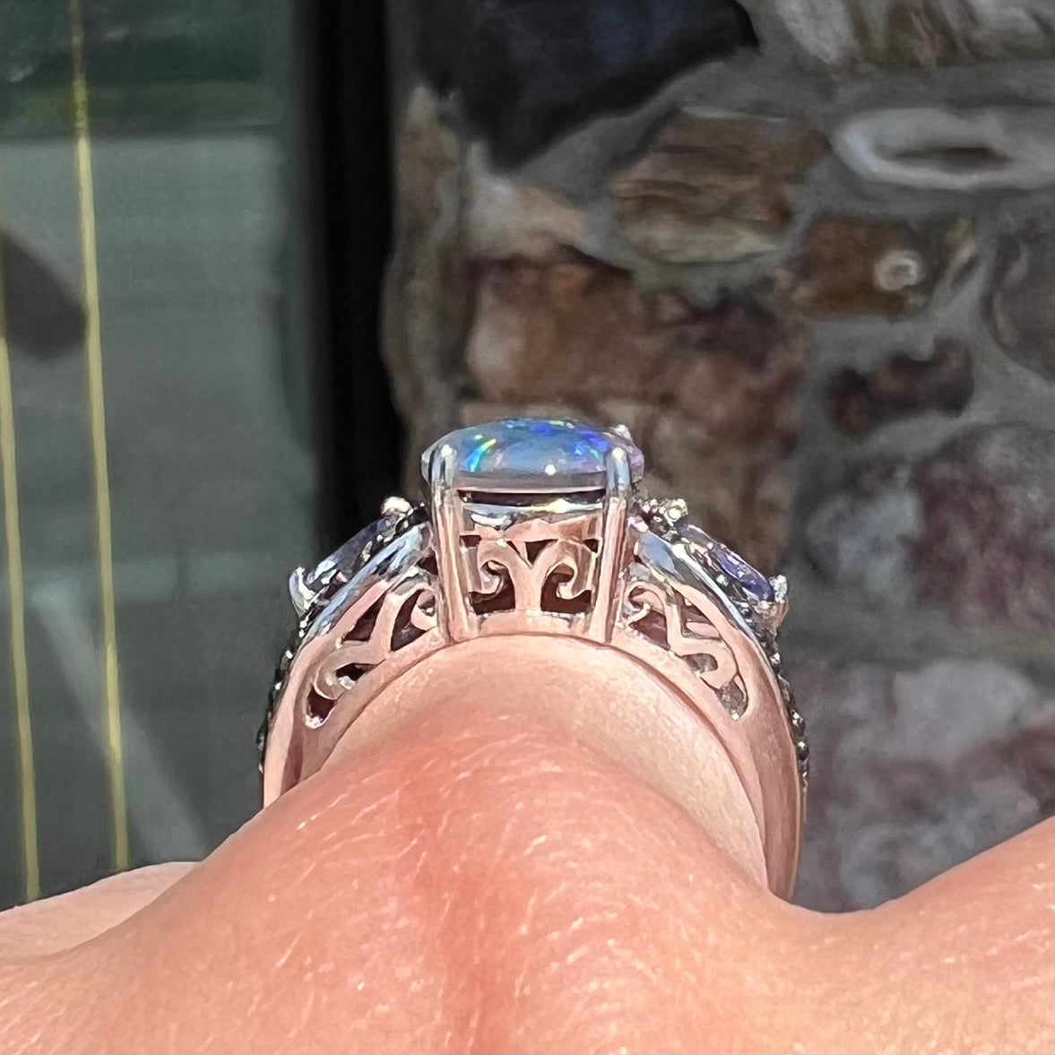 A sterling silver black opal triplet ring set with black spinel and marquise cut tanzanite accent stones.
