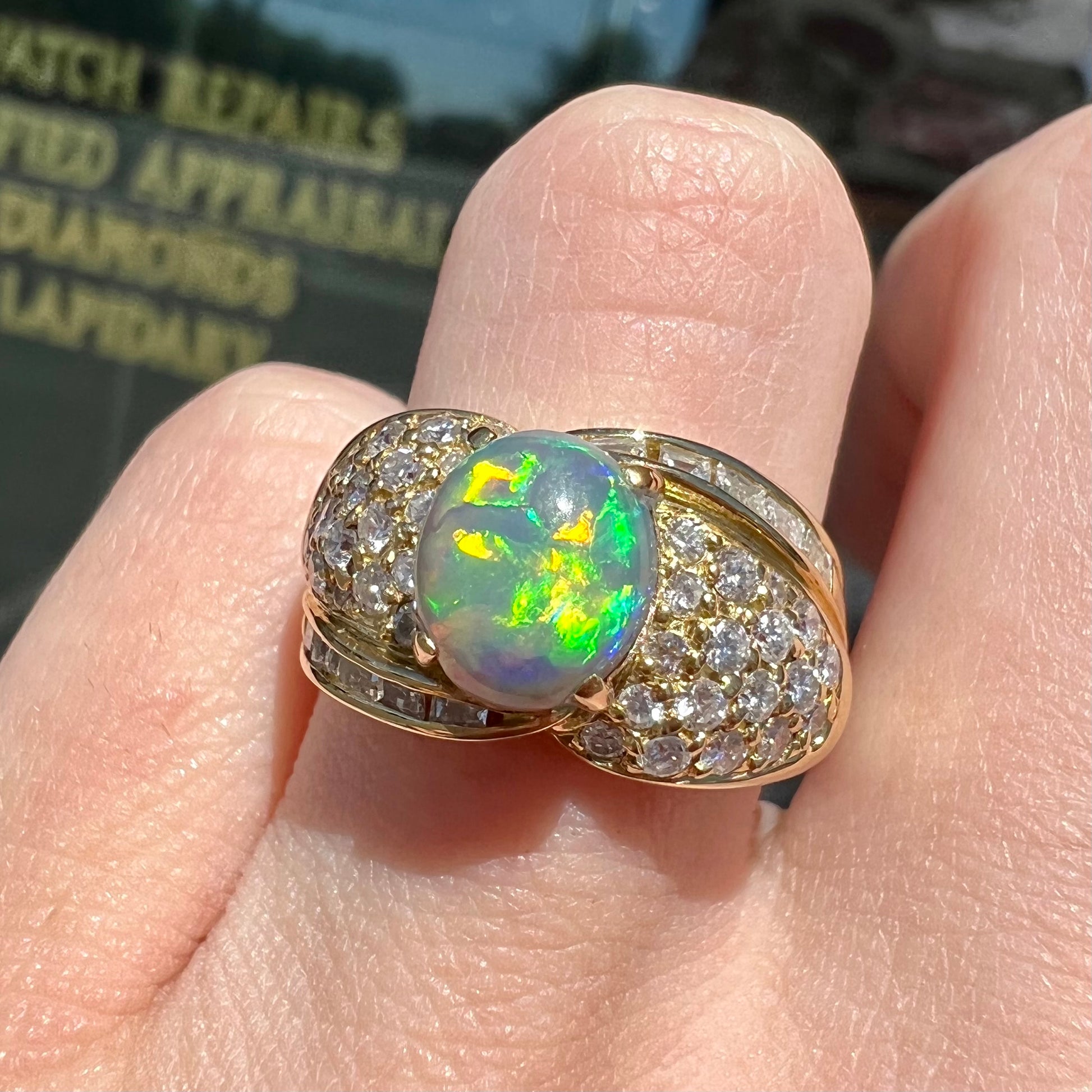 An 18kt yellow gold oval cabochon cut Lightning Ridge black opal ring.  The shank is set with round and baguette cut diamonds.