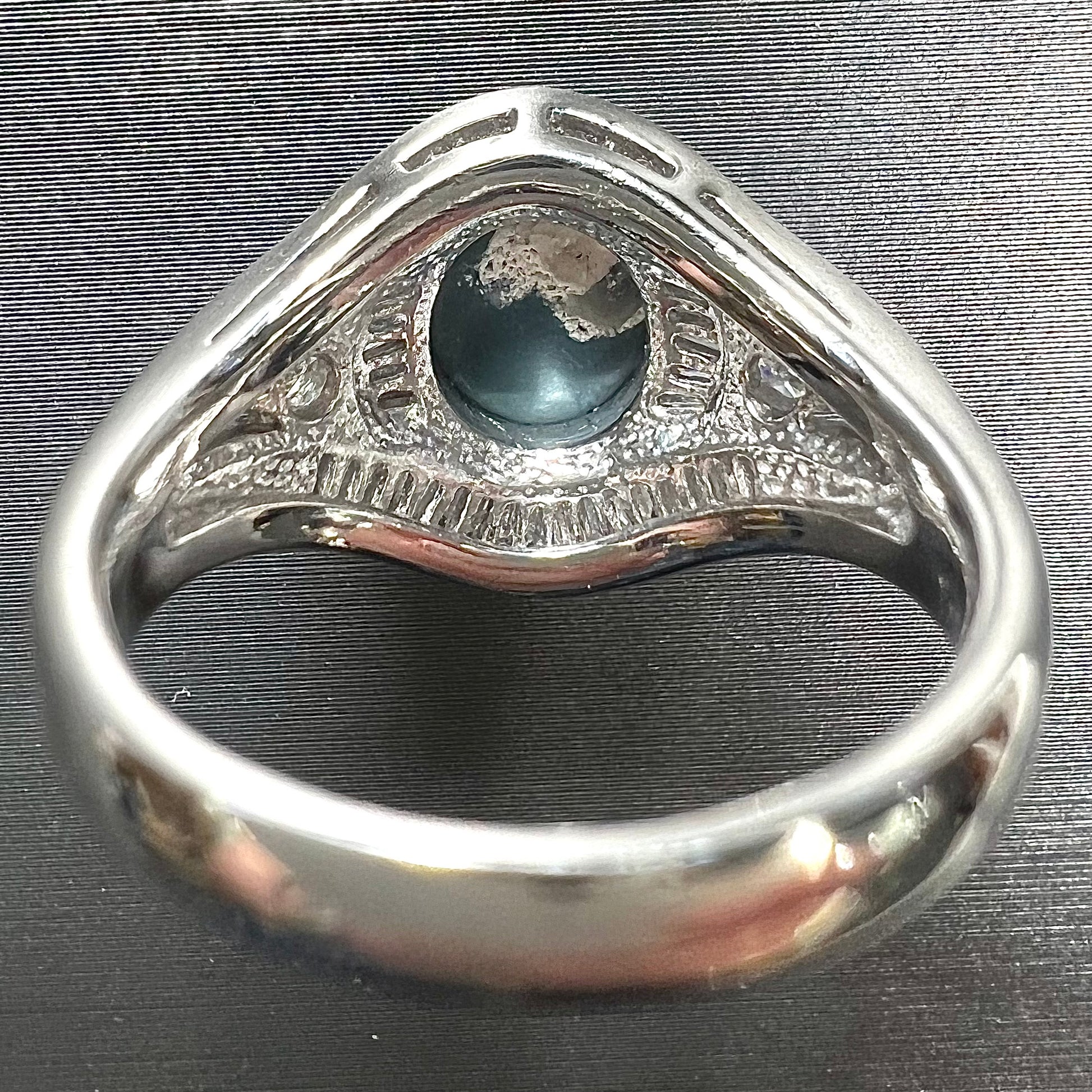 A platinum Lightning Ridge black opal ring set with baguette cut diamonds.  The opal is an oval cabochon cut.