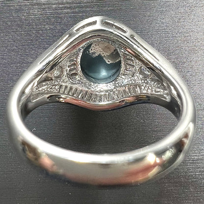 A platinum Lightning Ridge black opal ring set with baguette cut diamonds.  The opal is an oval cabochon cut.
