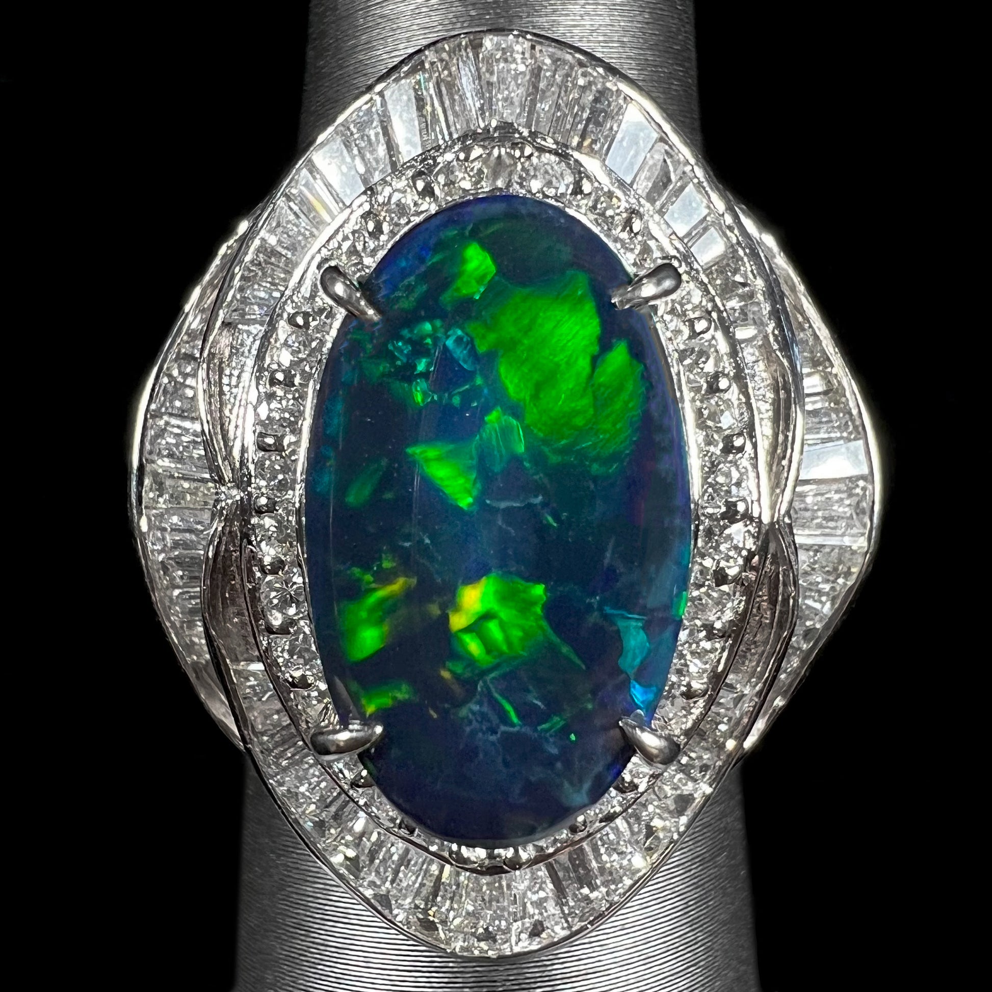 A ladies' platinum diamond halo ring set with a natural black opal stone from Lightning Ridge, Australia.