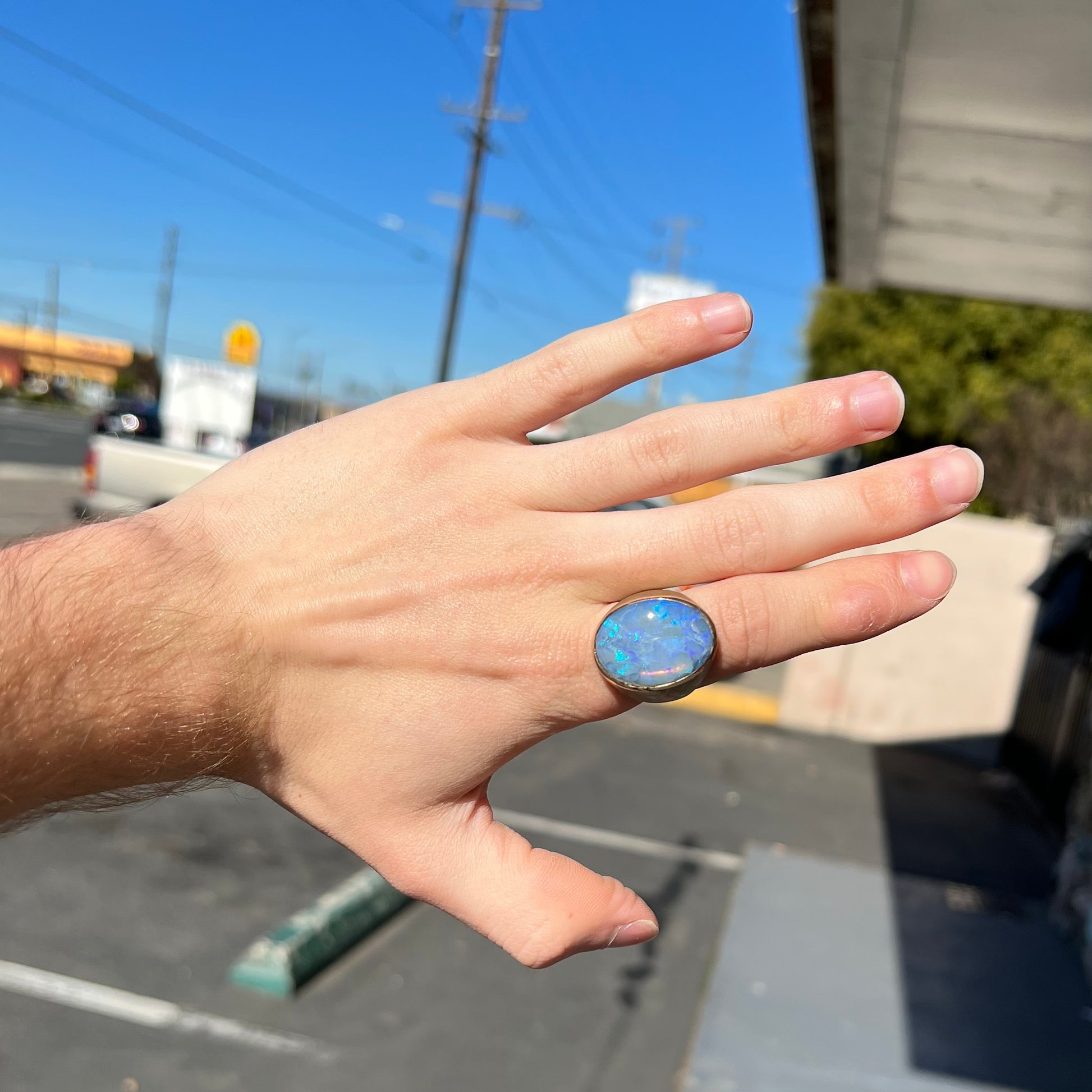 A Lightning Ridge black opal men's ring in solid yellow textured gold.