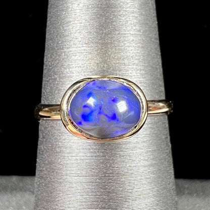 A ladies' black crystal opal solitaire ring set in yellow gold.