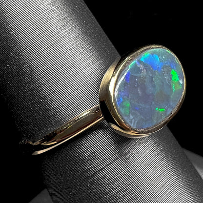 A ladies' yellow gold black opal solitaire ring from Lightning Ridge, Australia.