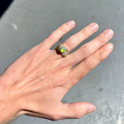 An 18kt yellow gold oval cabochon cut Lightning Ridge black opal ring.  The shank is set with round and baguette cut diamonds.