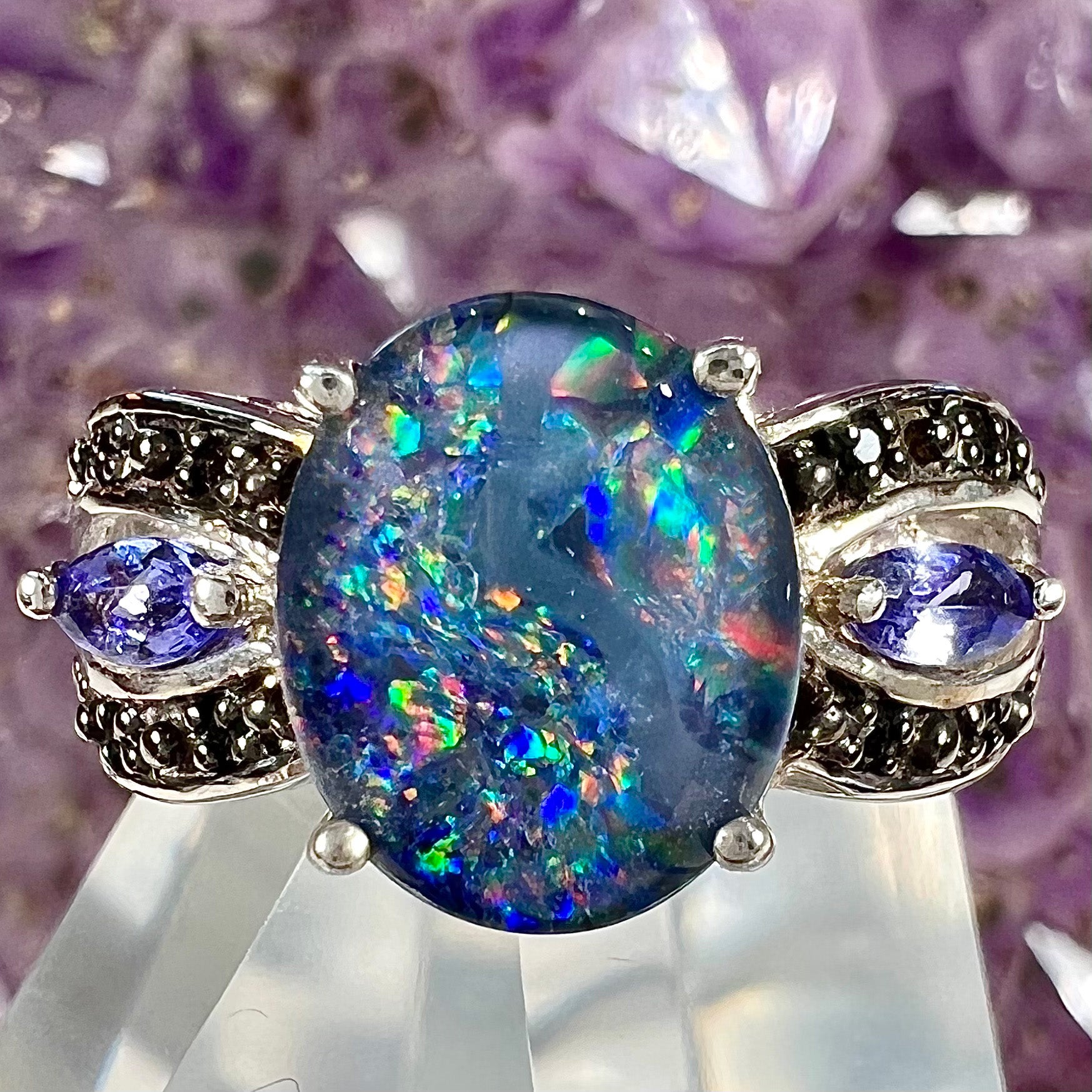 A sterling silver black opal triplet ring set with black spinel and marquise cut tanzanite accent stones.