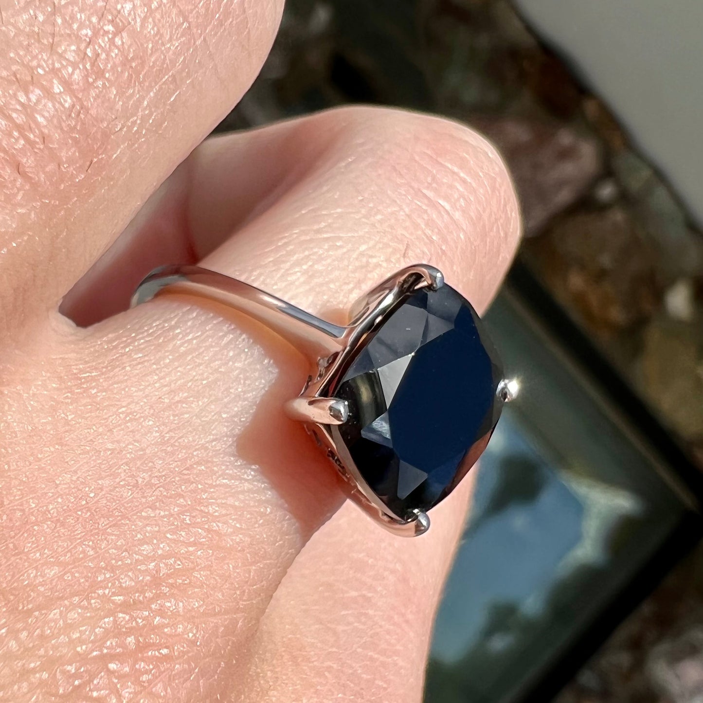 A cushion cut black spinel prong set in a sterling silver solitaire ring.