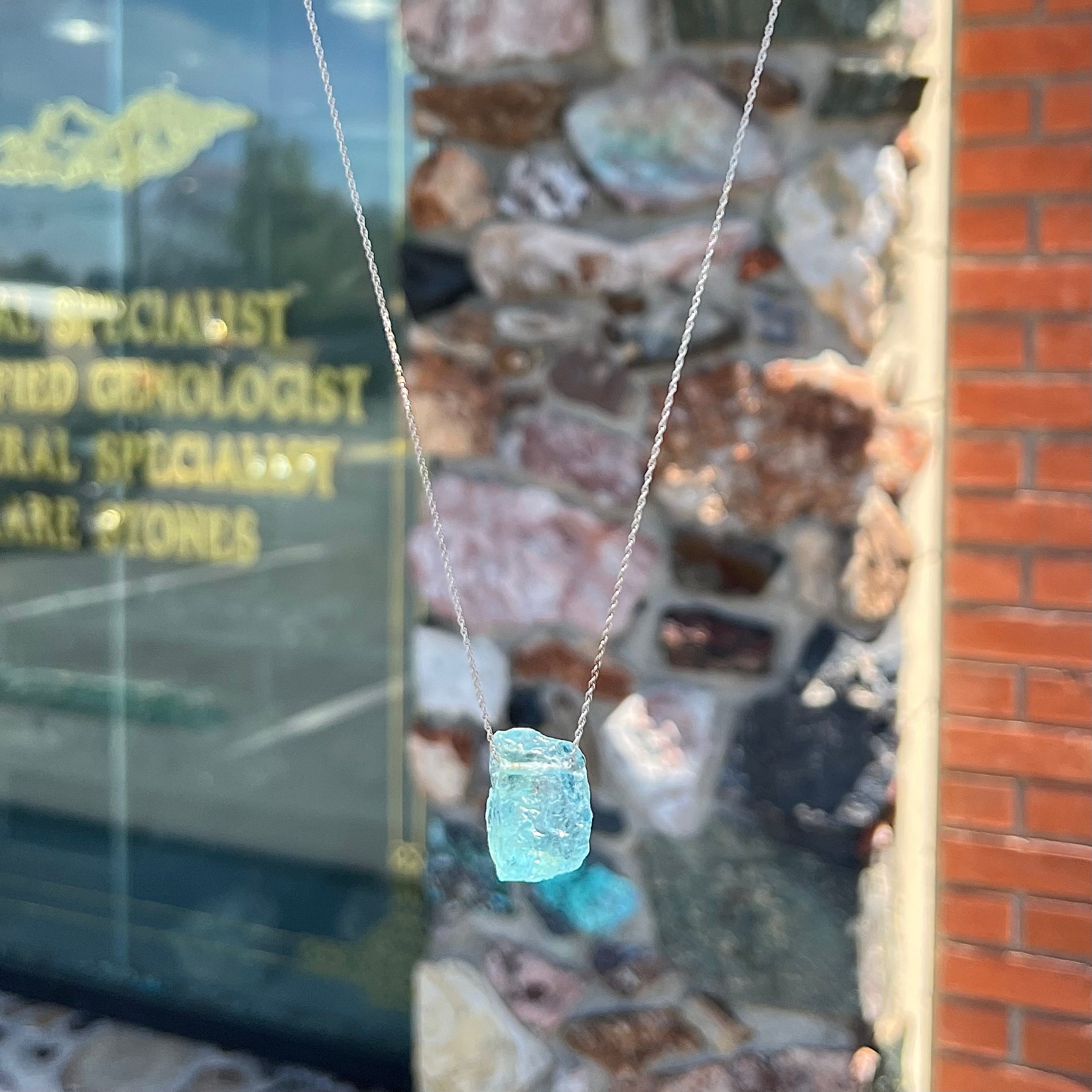A drilled aquamarine crystal necklace on a silver wheat chain.