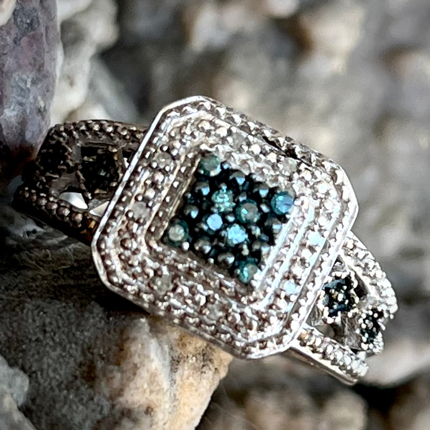 A sterling silver ring set with blue and white diamonds.