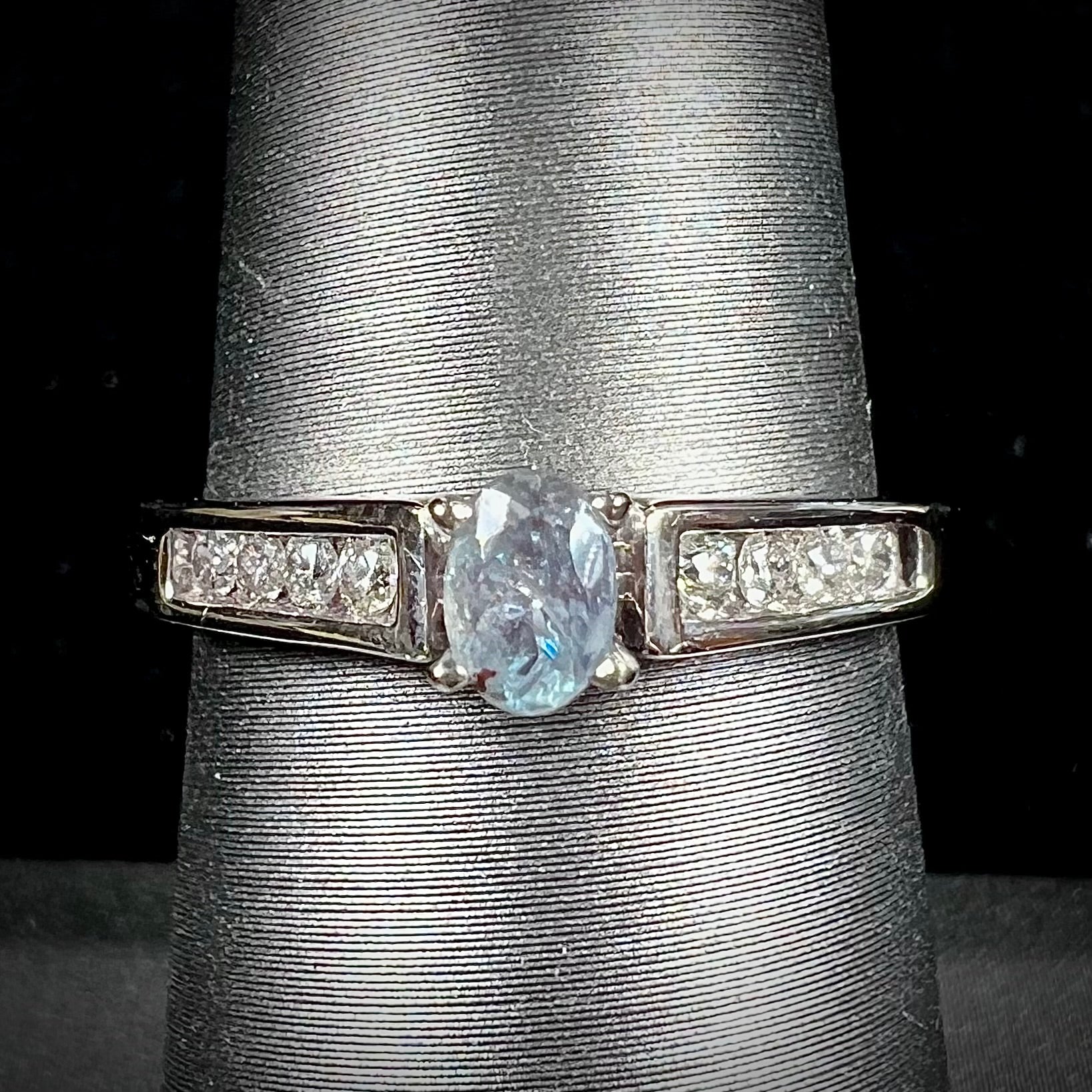 A ladies' white gold and diamond ring set with a 0.26ct alexandrite center stone that changes from green blue to lilac purple.
