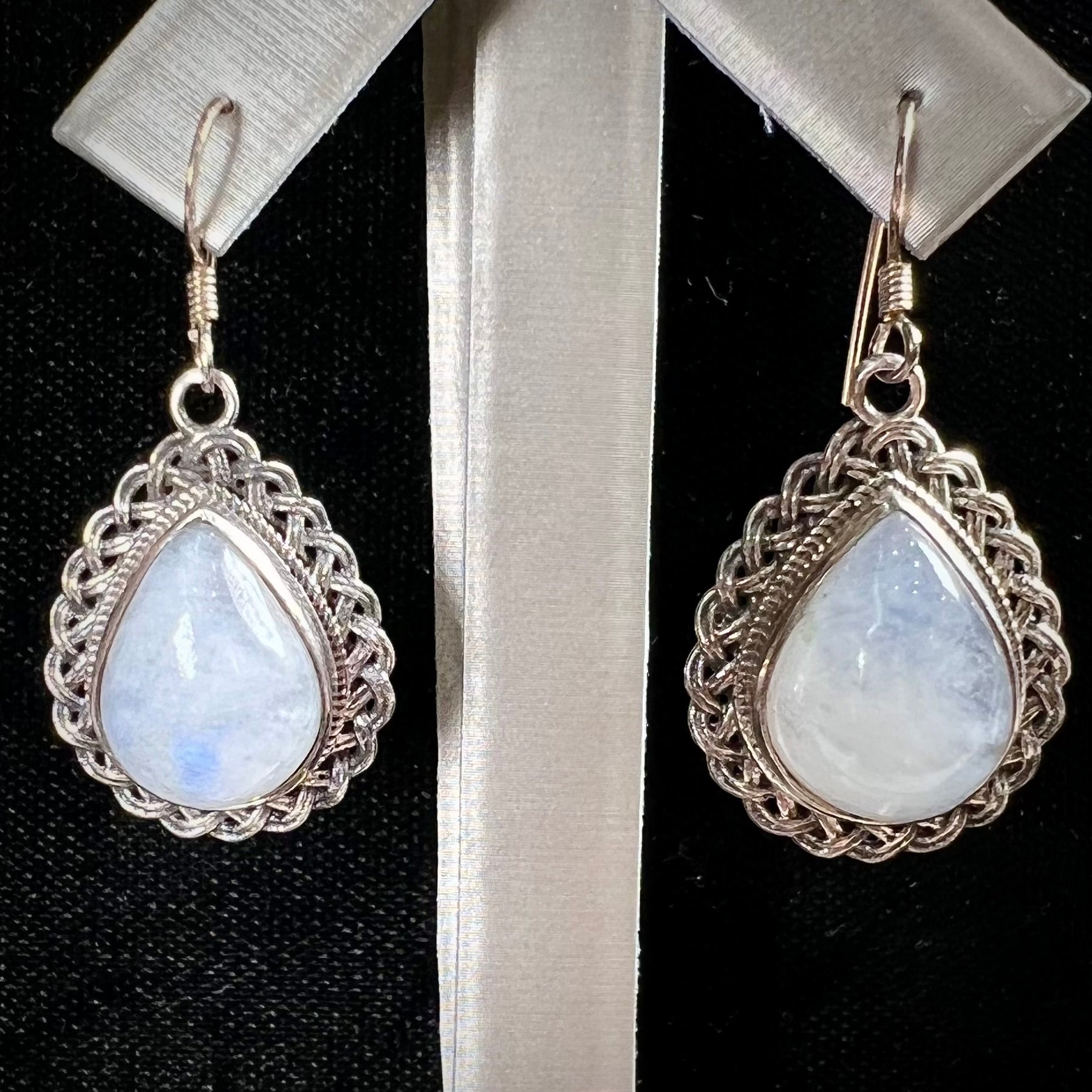 Silver filigree dangle wire earrings set with pear shape moonstones.