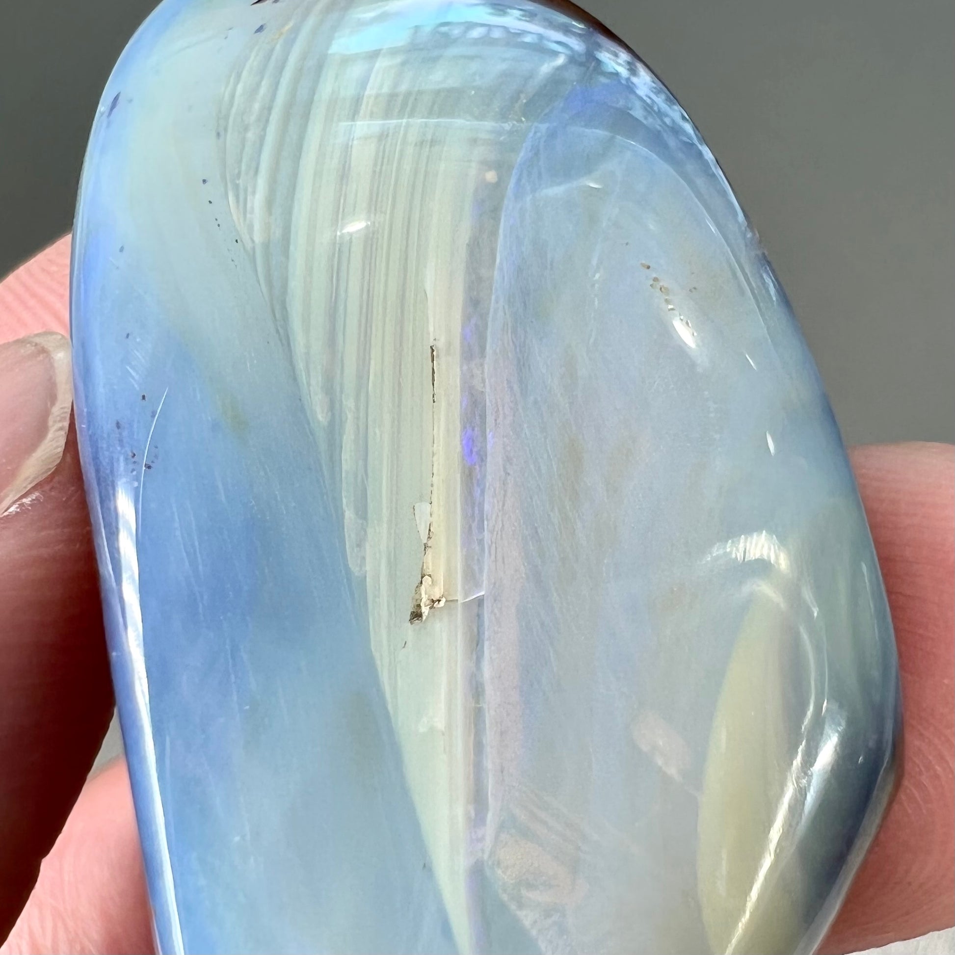 A loose, polished blue boulder opal stone from Queensland, Australia.