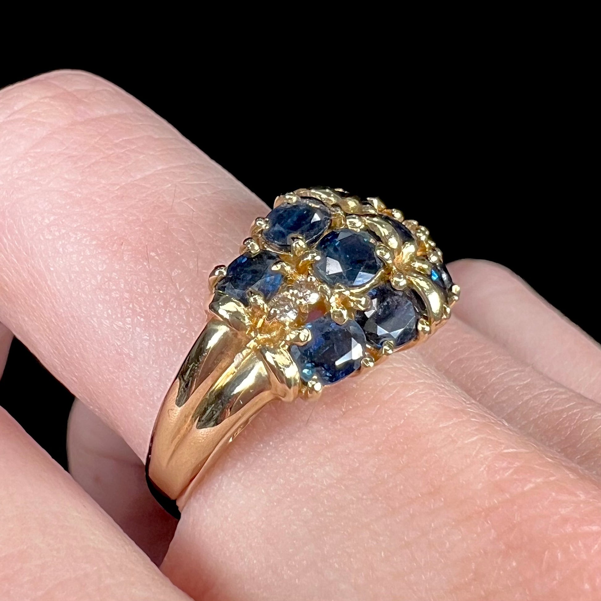 A vintage ladies' blue sapphire and diamond cluster ring cast in yellow gold.