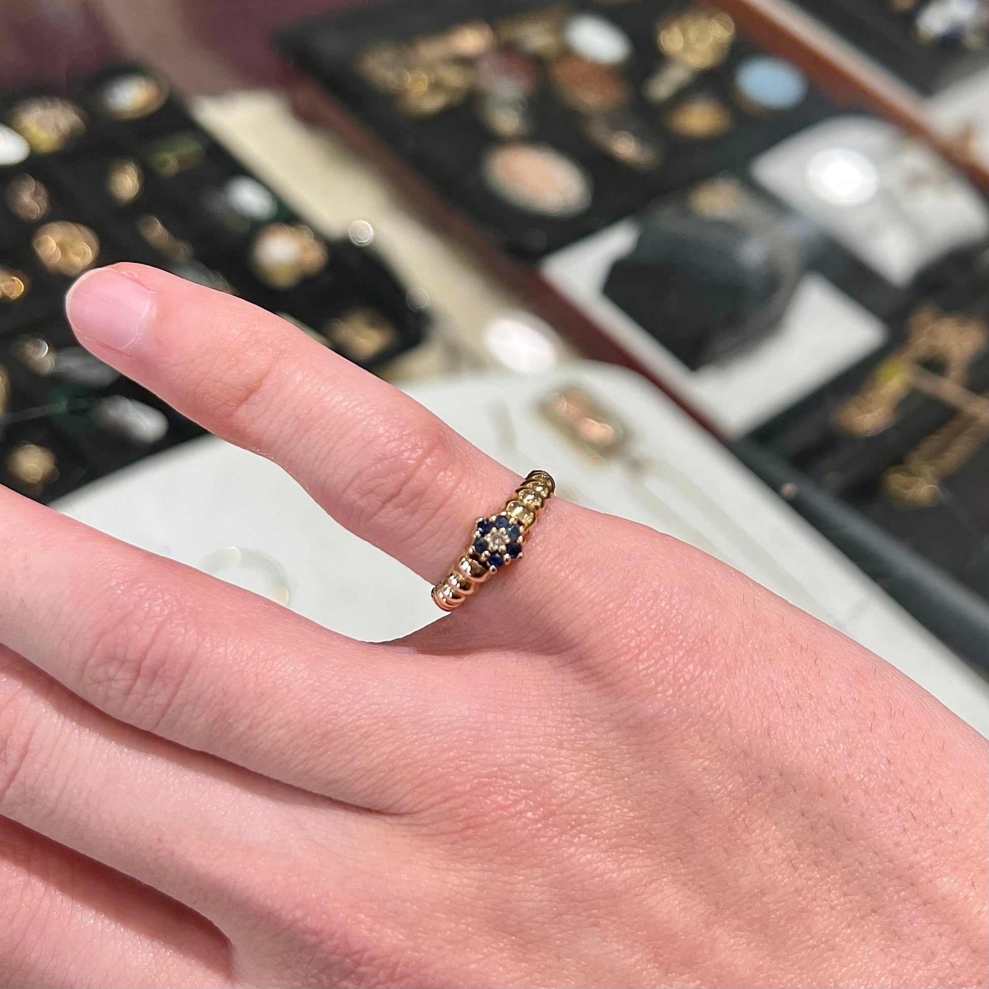 A ladies' yellow gold cluster ring set with round blue sapphires and a round diamond.