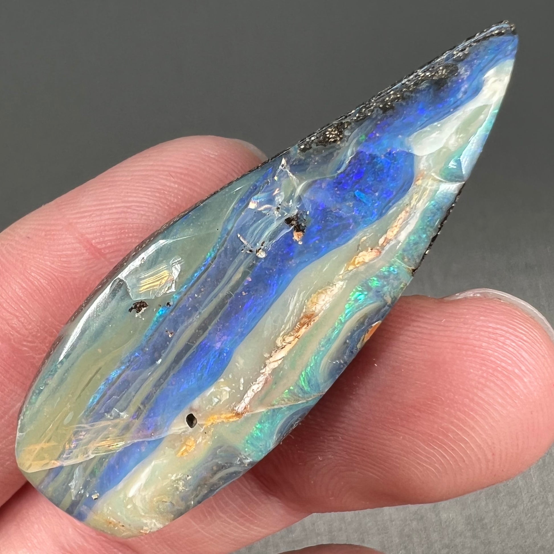 A loose, pear shaped boulder opal stone from Queensland, Australia.