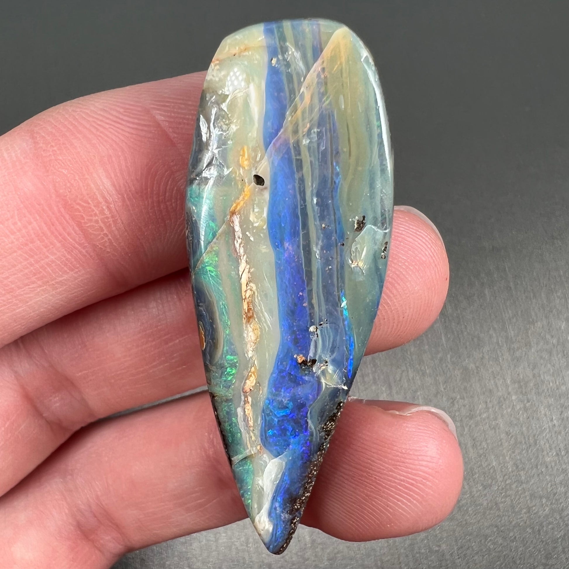 A loose, pear shaped boulder opal stone from Queensland, Australia.