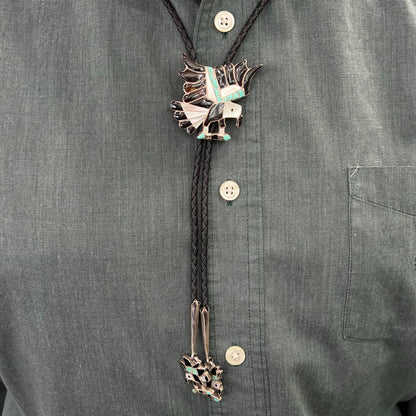 A sterling silver Zuni Indian-made bolo tie featuring the motif of three flying eagles inlaid with natural stones.