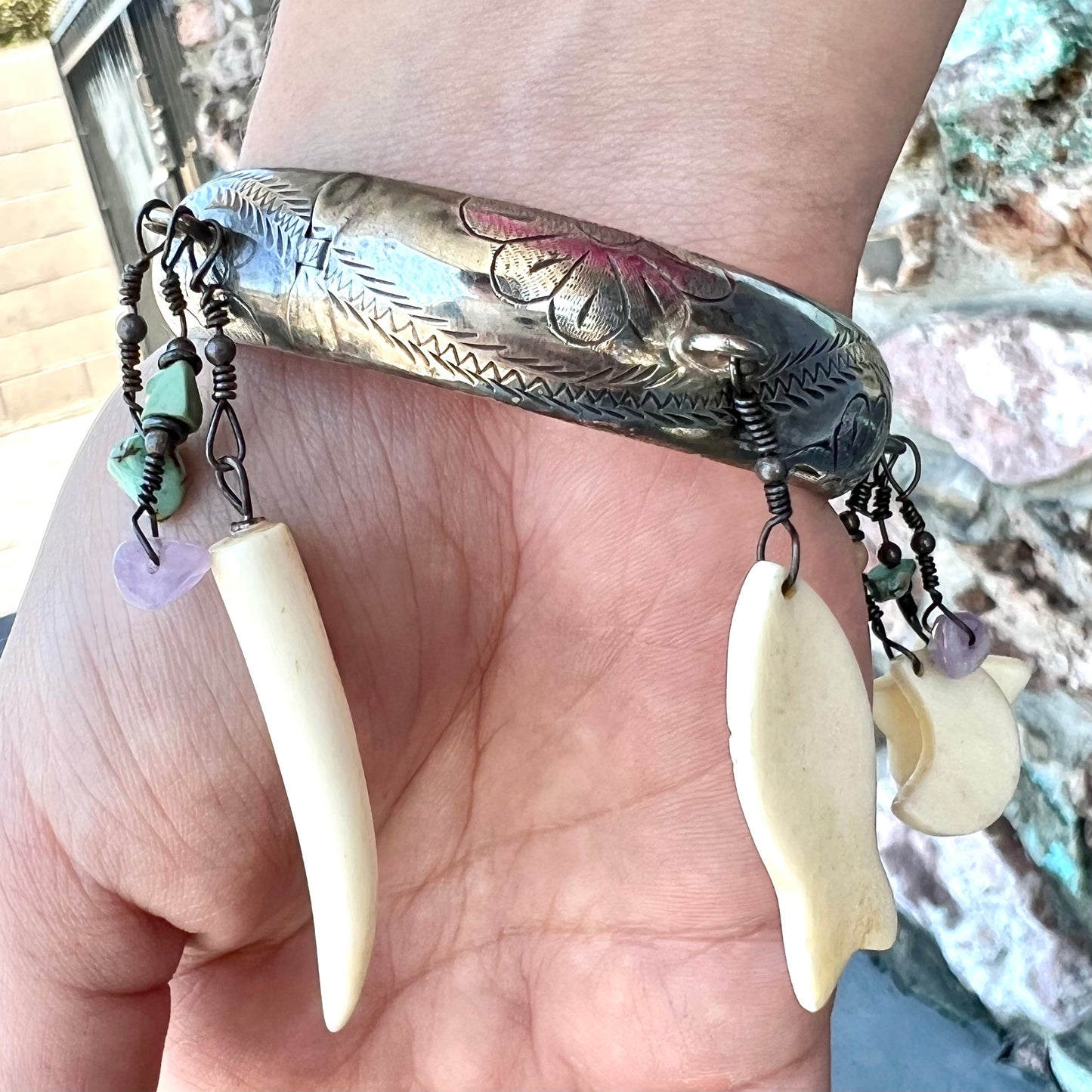 A Native American sterling silver bangle bracelets attached with carved bone, gemstone, and silver charm fetishes.