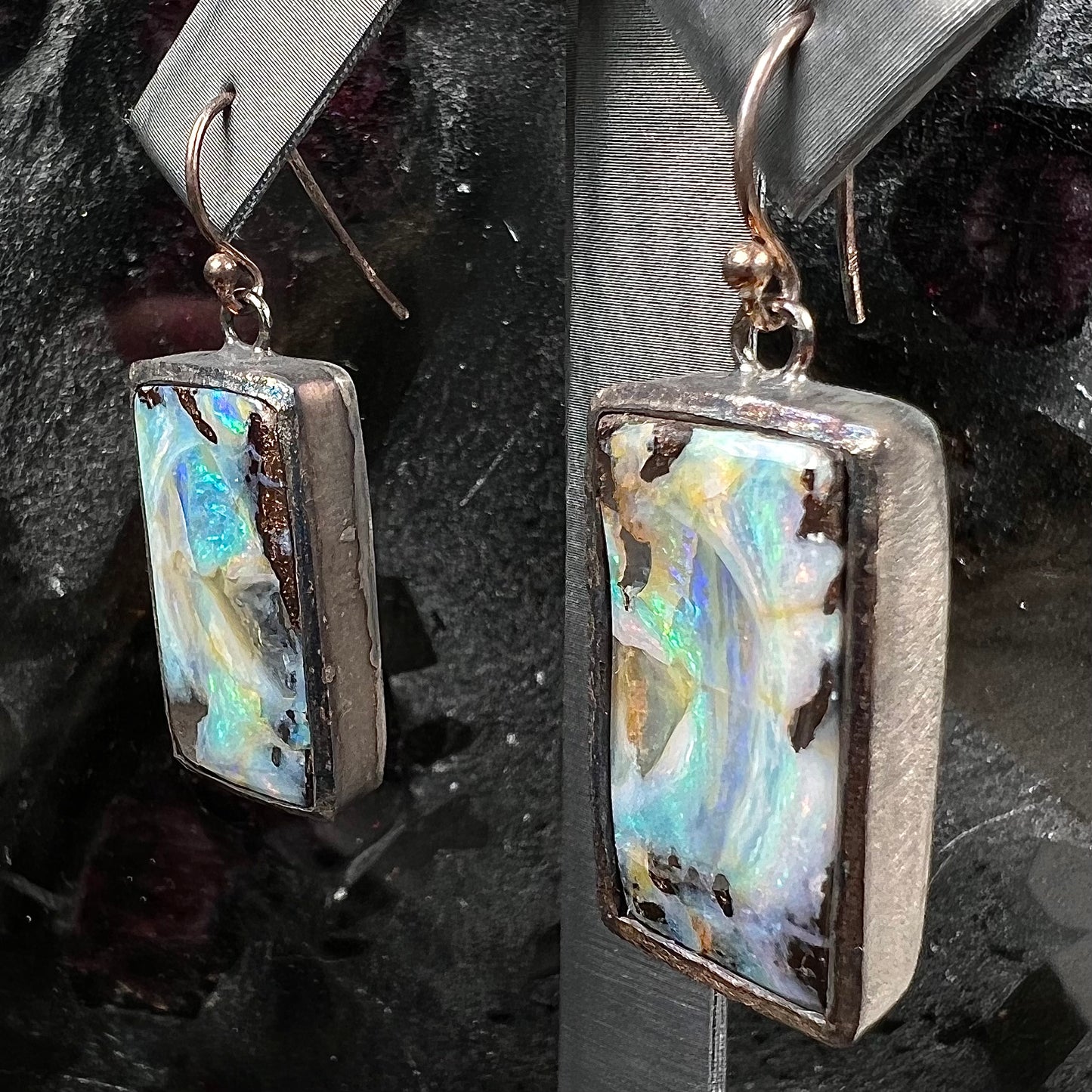 A pair of handmade sterling silver boulder opal earrings.  The earrings dangle from French wire hooks.