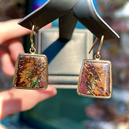 A pair of yellow gold French wire dangle earrings set with Koroit boulder opal.