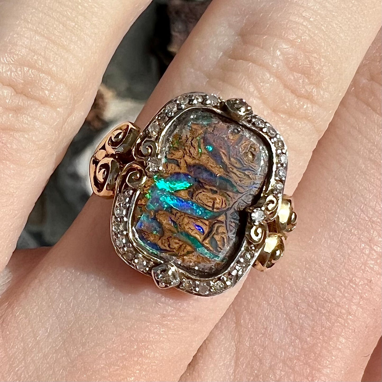 Striped Koroit boulder opal set in a filigree 14k yellow gold setting with diamonds.  The filigree has a heart pattern.