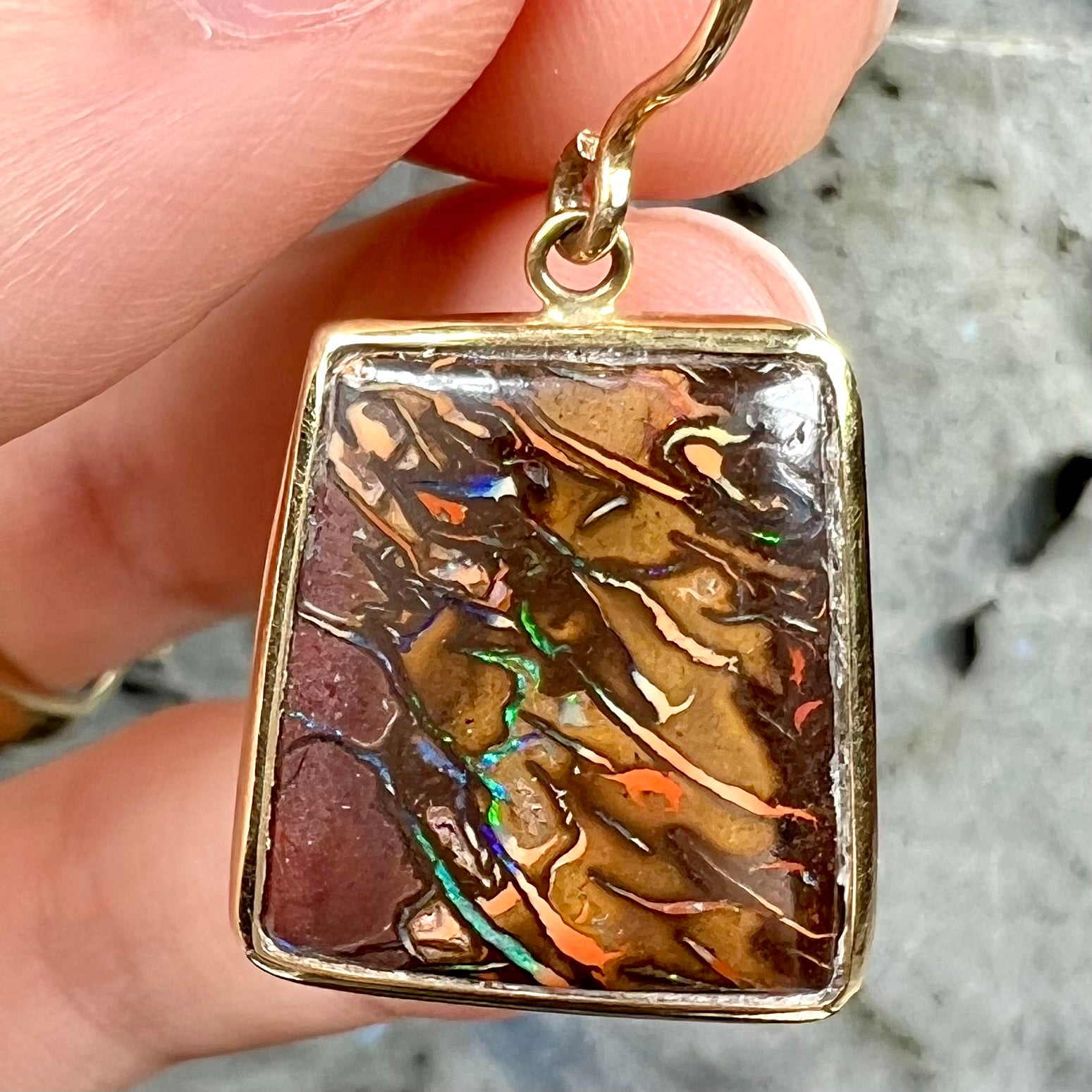 A pair of yellow gold French wire dangle earrings set with Koroit boulder opal.