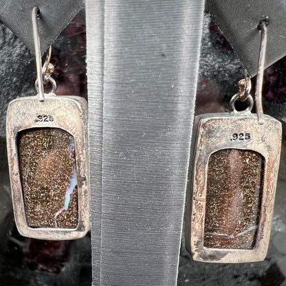 A pair of handmade sterling silver boulder opal earrings.  The earrings dangle from French wire hooks.