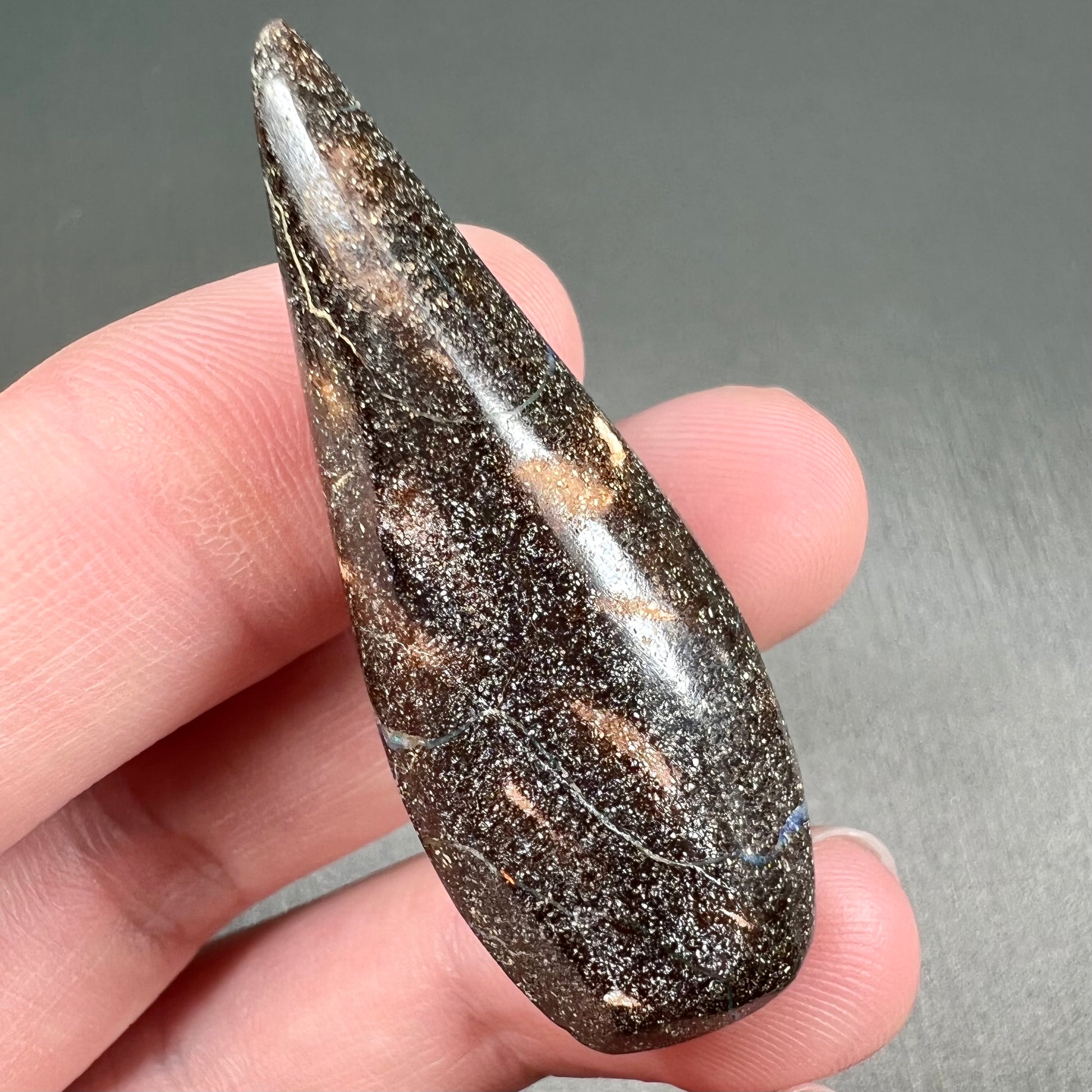 A loose, pear shaped boulder opal stone from Queensland, Australia.