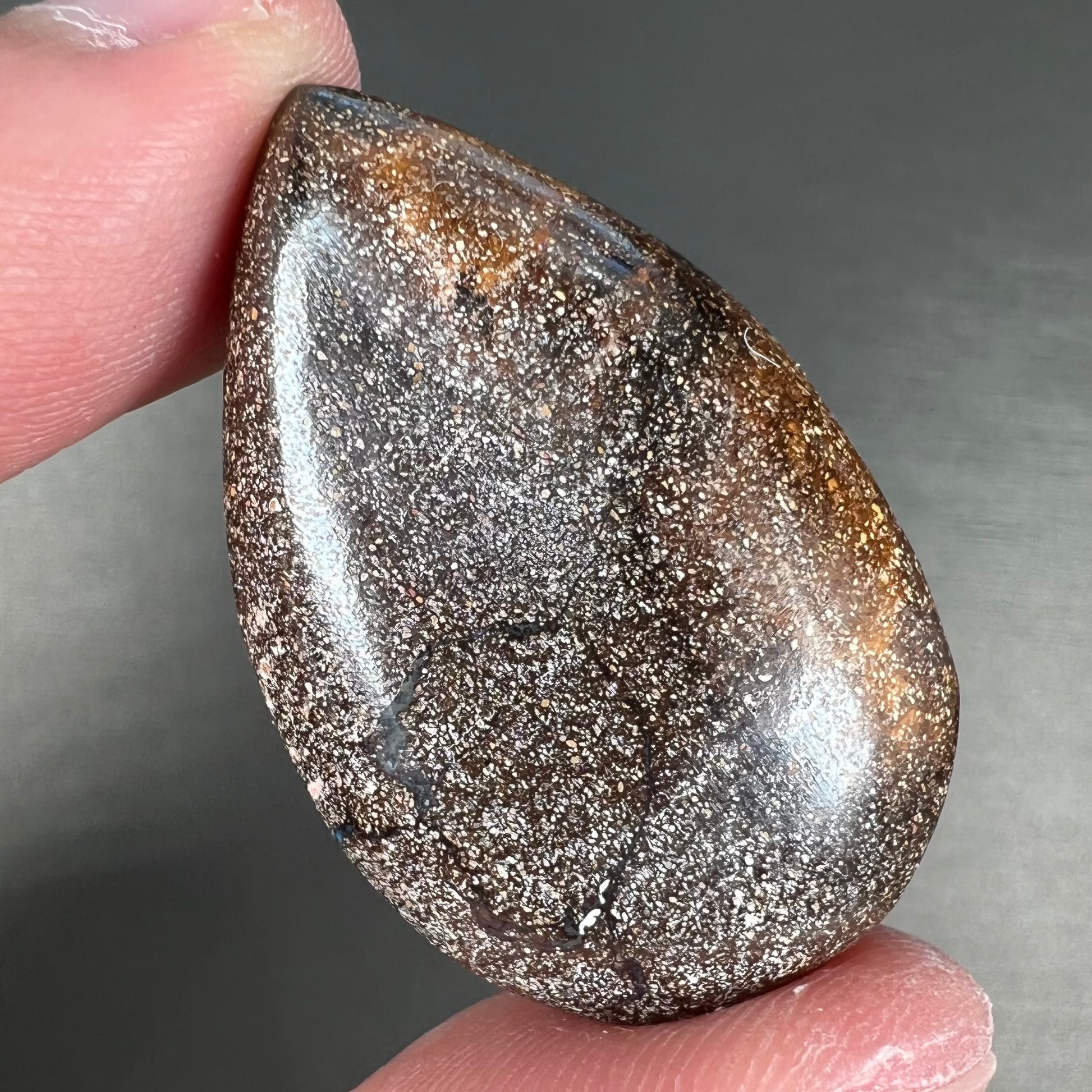 A loose, pear shaped cabochon cut boulder opal stone from Quilpie, Australia.