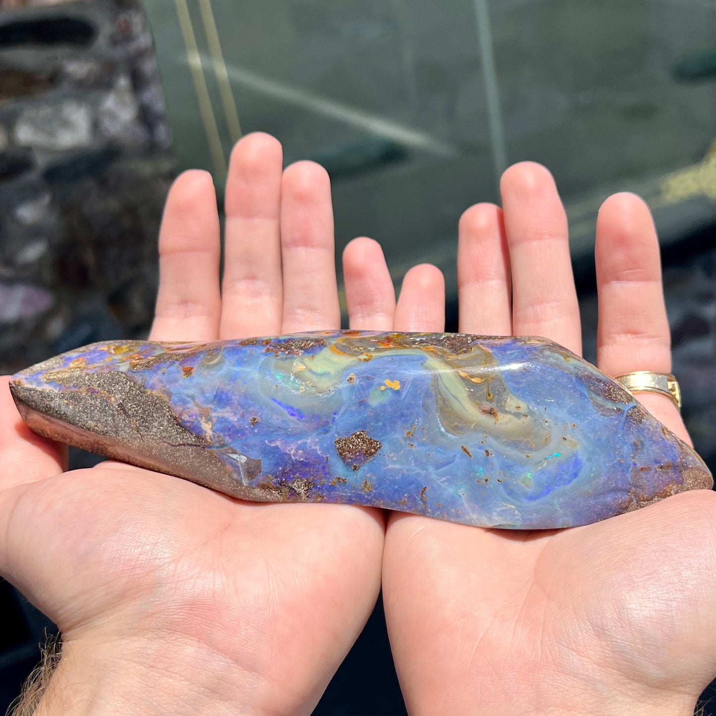 A 7 inch long polished blue Quilpie boulder opal specimen from Queensland, Australia.
