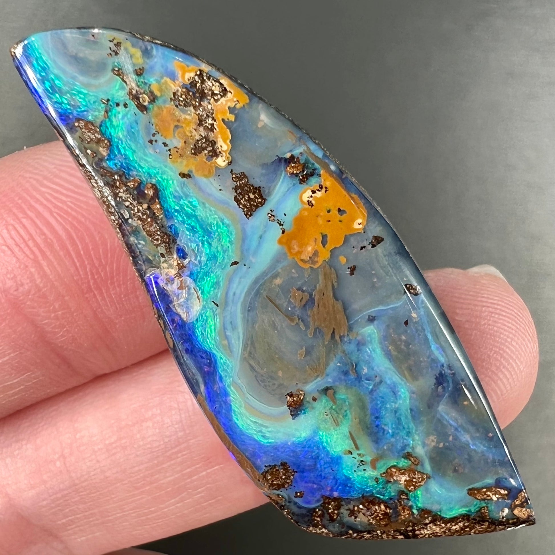 A freeform cut, loose black boulder opal stone from Queensland, Australia.