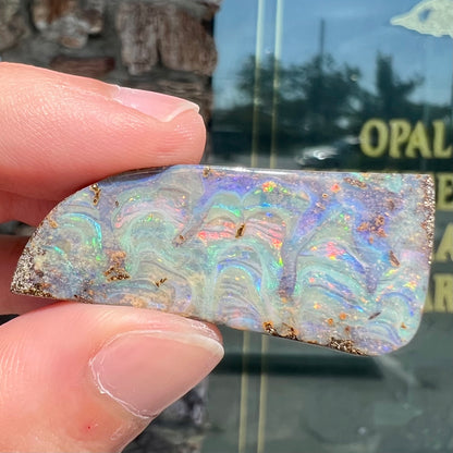 A loose, freeform cut, natural boulder opal stone from Quilpie, Australia.
