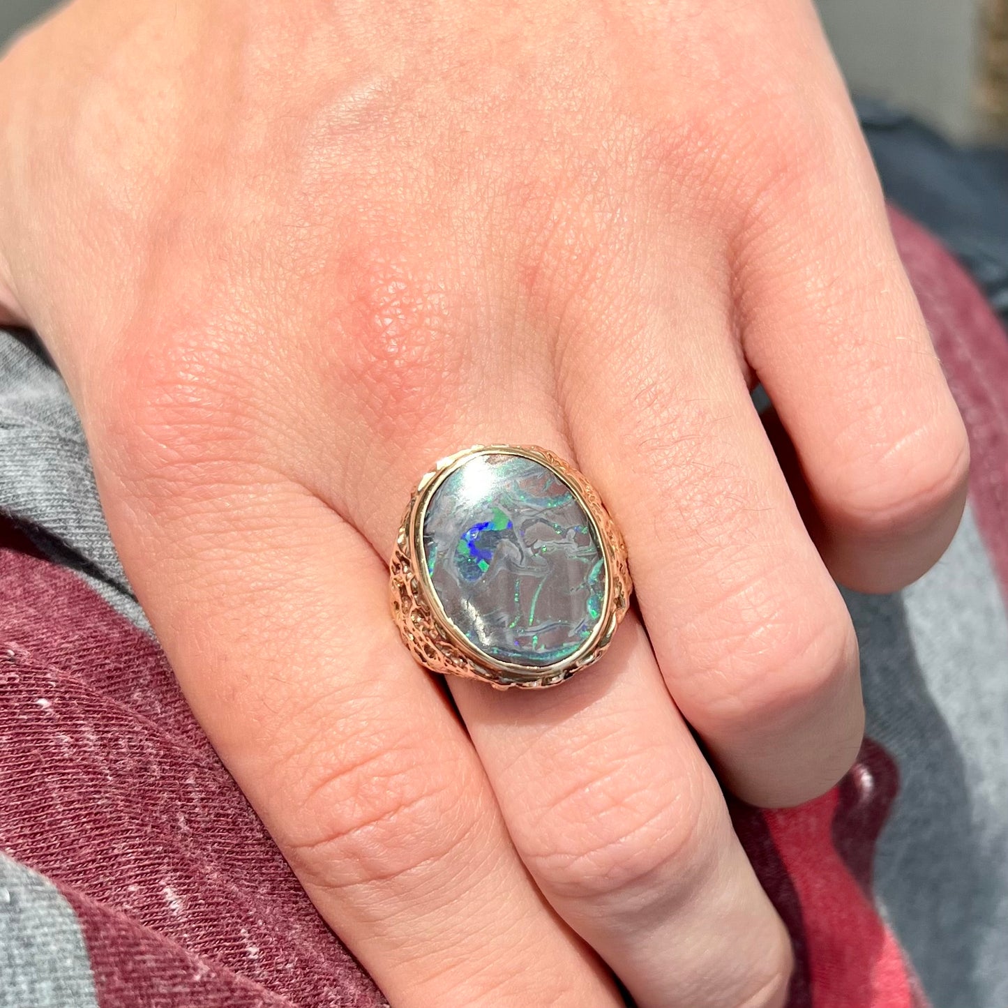 A men's yellow gold nugget style Koroit boulder opal solitaire ring.