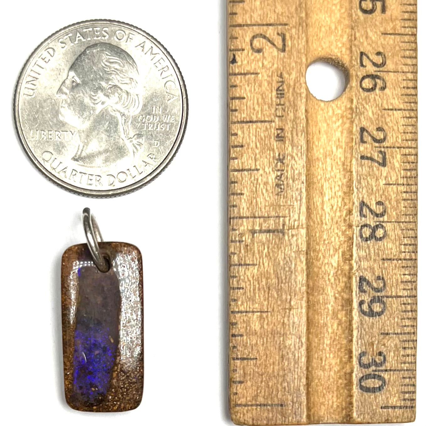 A drilled boulder opal stone with a sterling silver ring through the hole to be worn as a pendant.