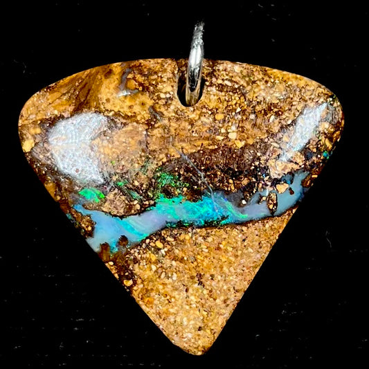 A drilled boulder opal stone with a sterling silver ring through the hole to be worn as a pendant.