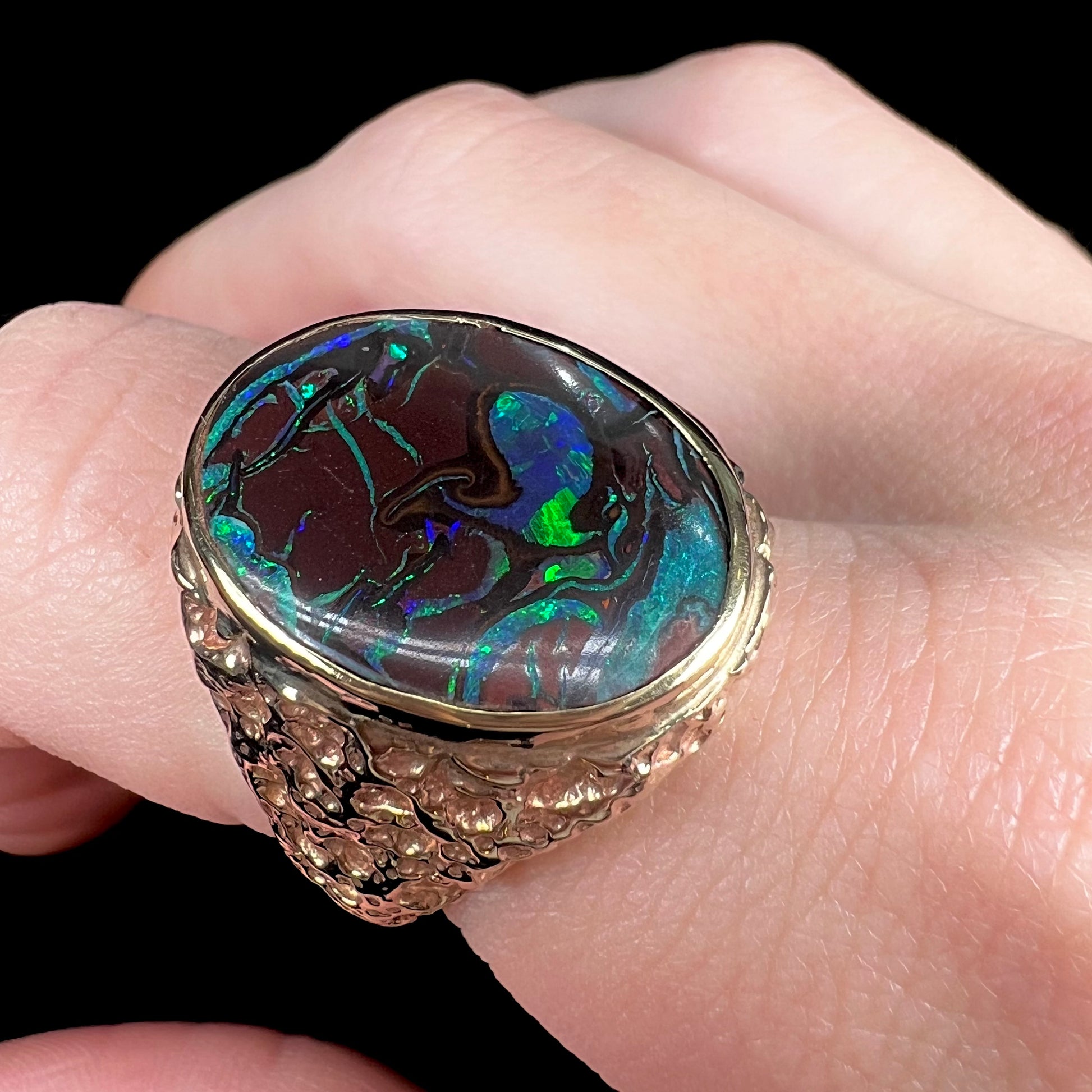 A men's yellow gold nugget style Koroit boulder opal solitaire ring.