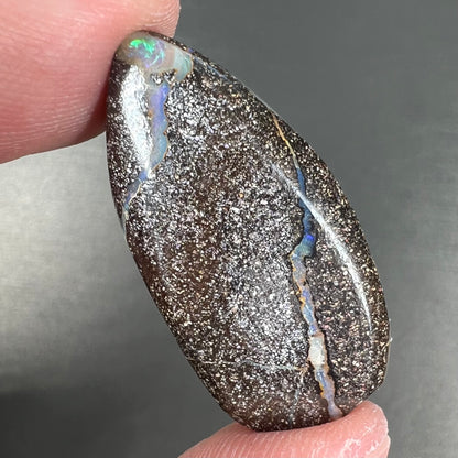 A loose, pear shaped cabochon cut boulder opal stone from Quilpie, Australia.