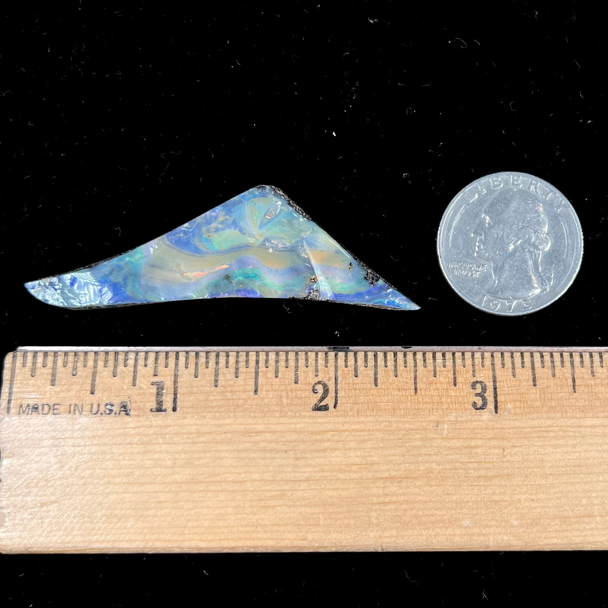 A loose, triangular shaped boulder opal stone from Queensland, Australia.